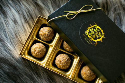 Holiday cheer and egg nog bourbon balls!  Noggy or Nice is back and embodies the holiday season, Christmas traditions and a little nostalgic naughtiness.   Creamy white chocolate from France, toasted pecans, freshly ground nutmeg, are blended together with Holladay Distillery Bourbon Whiskey and Egg Nog Liqueur, and rolled in crushed, homemade vanilla wafers with added nutmeg.  Holiday gifts, Kansas City gifts.  White chocolate.  Bourbon balls.  Bourbon chocolates.  Bootleg Bourbon Balls